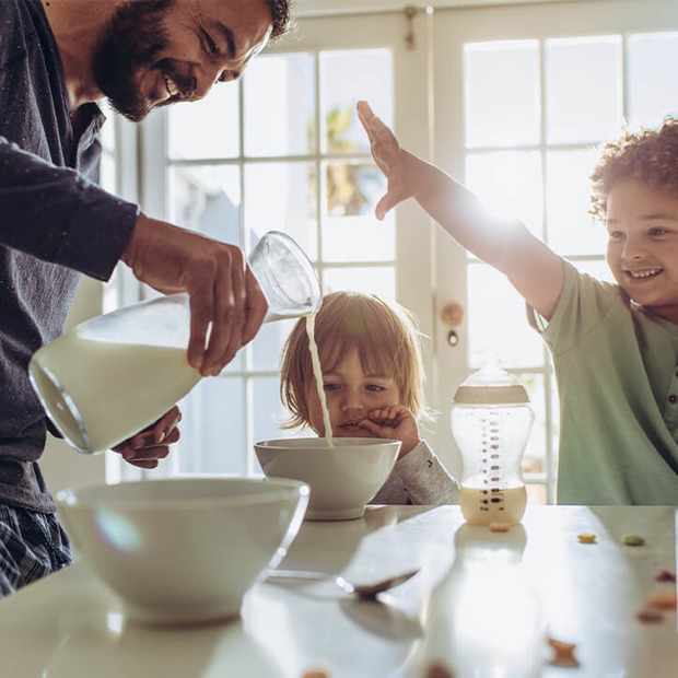 Vater bereitet calciumreiches Frühstück für seine Kinder zu.